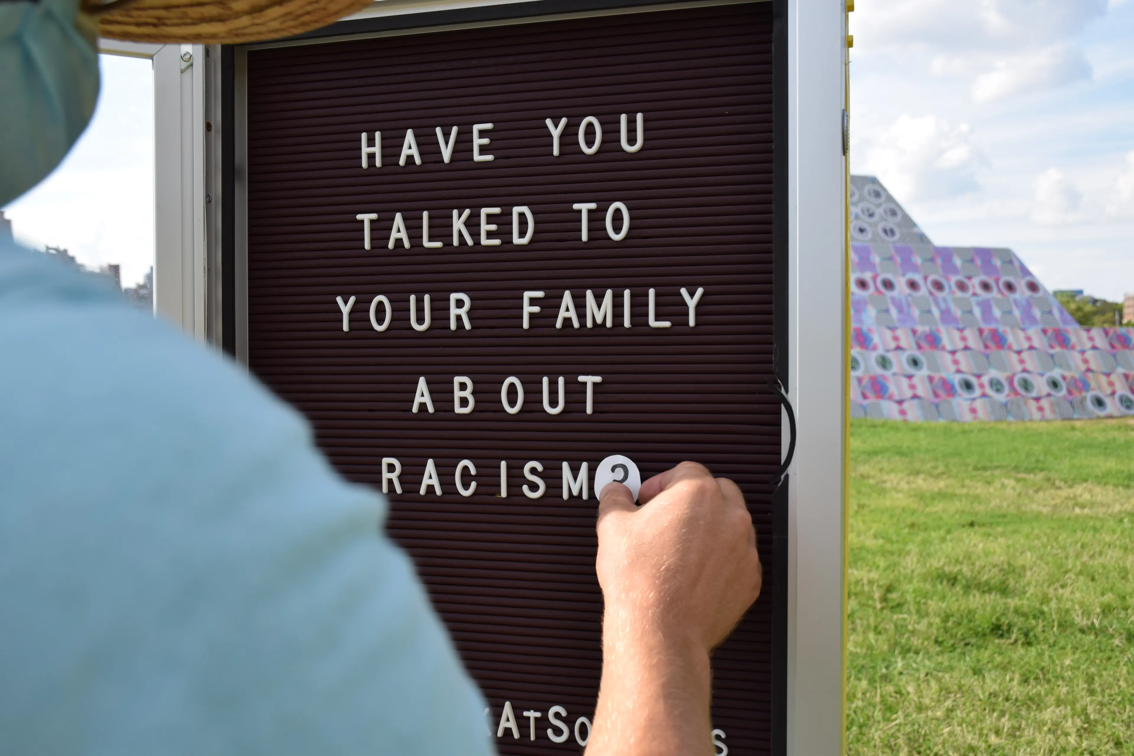 Close up photo of arranging letters on a sign that says "Have you talked to your family about racism"