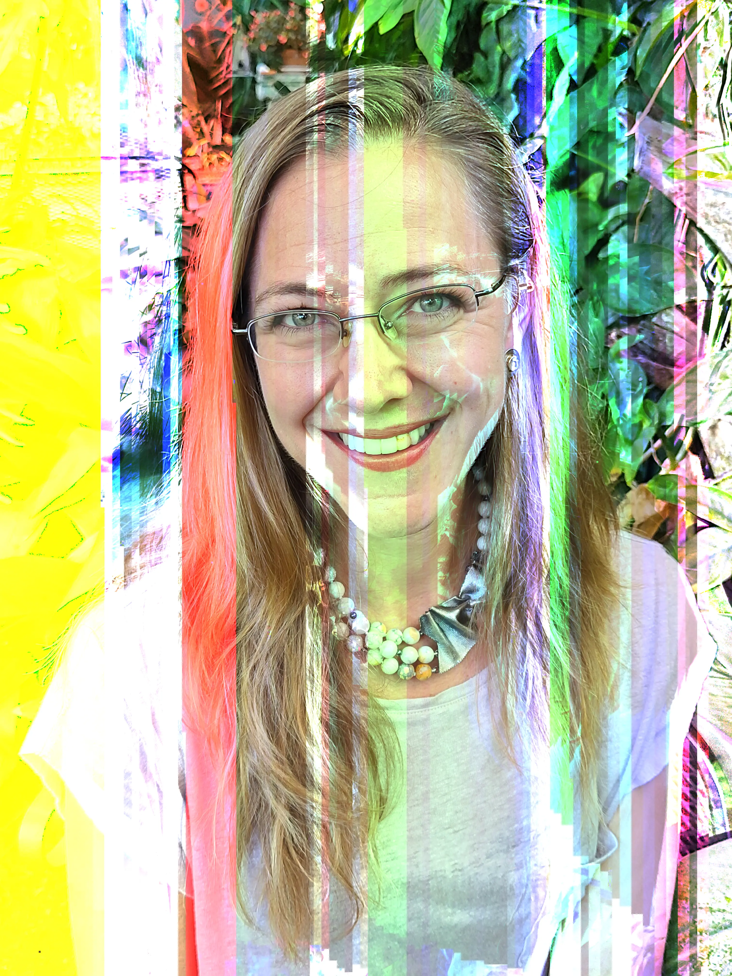Photo of Minka Stoyanova with glasses, a smile, and large beaded necklace wearing a white shirt.